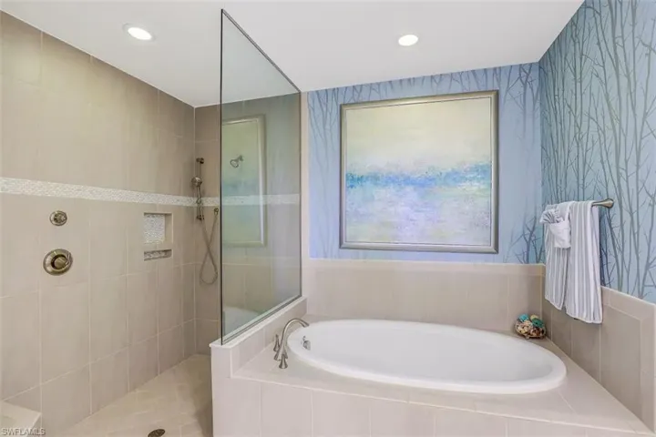 Bathroom with a bath, a walk in shower, and recessed lighting