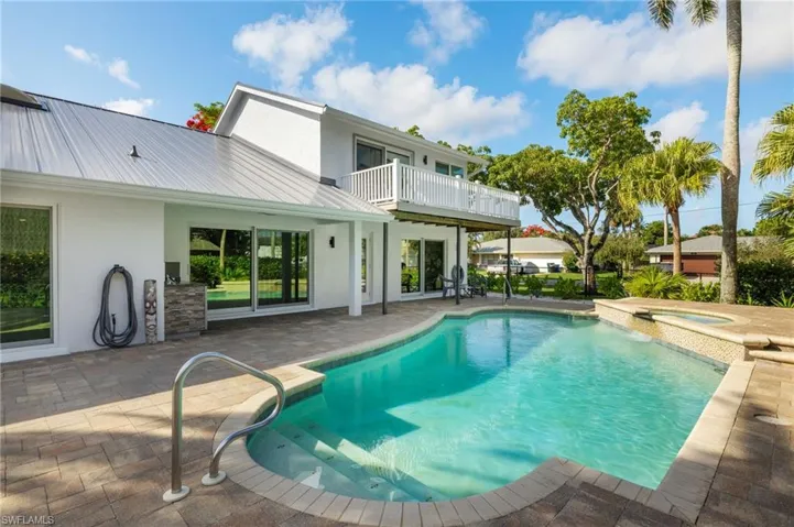 View of swimming pool featuring a patio and a pool with connected cool water spa