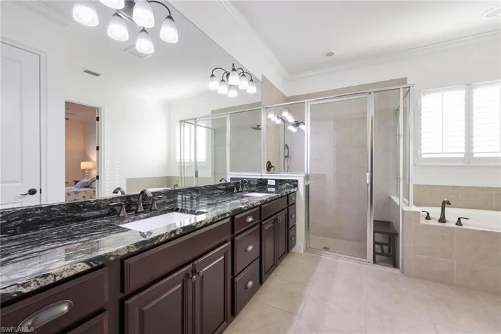 Ensuite bathroom with ornamental molding, a garden tub, a sink, and ensuite bath
