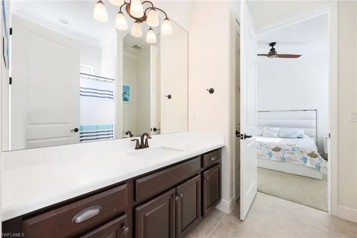 Ensuite bathroom featuring visible vents, ensuite bath, tile patterned flooring, crown molding, and vanity
