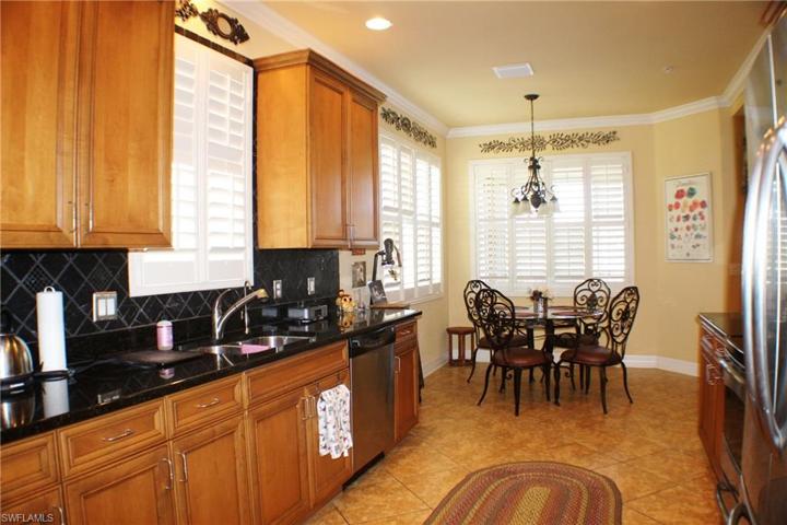 Kitchen features Lovely Maple wood cabinetry with 42" upper cabinets, Granite counters, Spacious Breakfast room, Stainless appliances, Crown Molding, Plantation shutters and Lake Views!