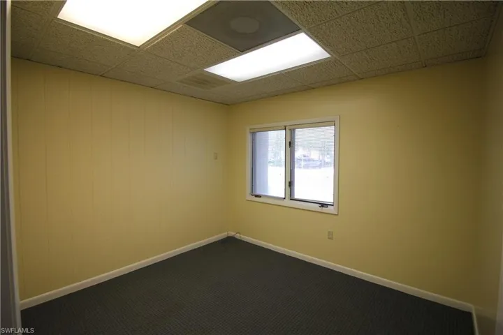 Unfurnished room featuring a paneled ceiling and carpet flooring