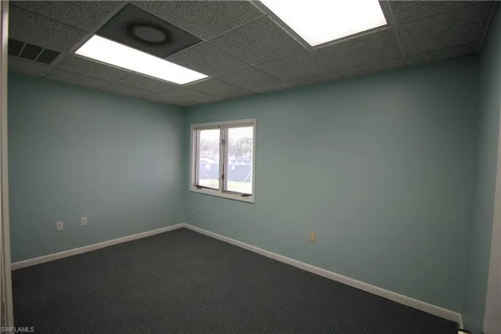 Empty room featuring a drop ceiling