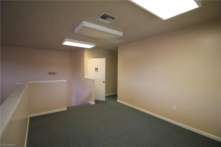 Spare room featuring dark carpet
