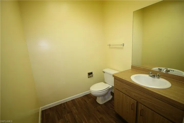 Bathroom featuring wood-type flooring, vanity, and toilet