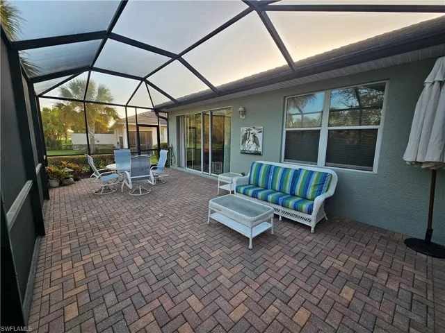 Patio terrace at dusk featuring a lanai