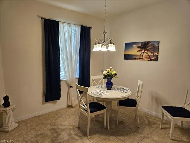 Tiled dining room featuring a chandelier