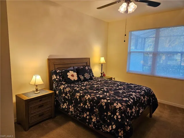 Bedroom featuring ceiling fan and dark carpet