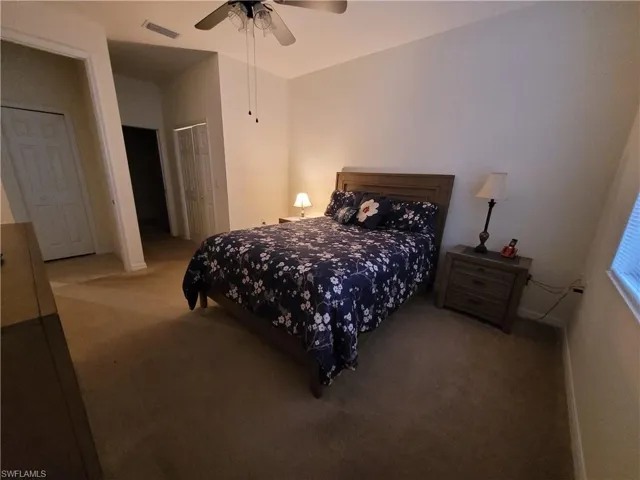 Bedroom with ceiling fan, a closet, and carpet flooring