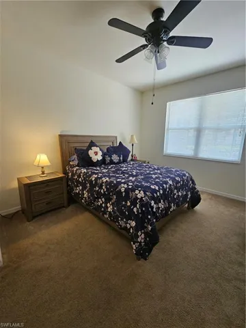 Bedroom featuring dark carpet and ceiling fan