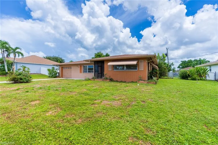 Single-story residence featuring a front lawn and paved driveway