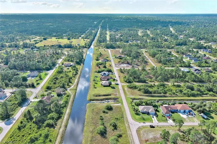 Aerial view of property's location with a large body of water and nearby suburban area