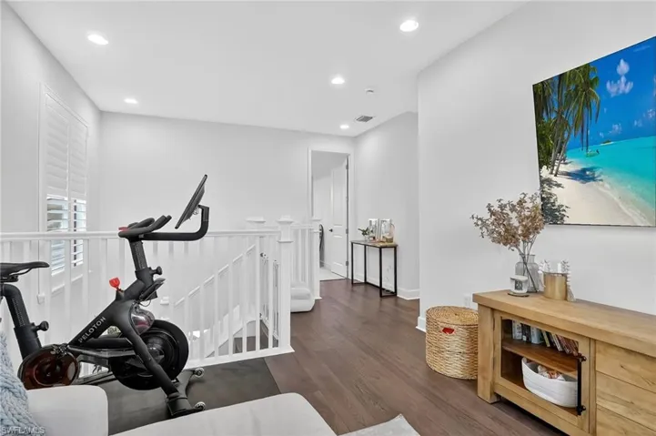 Workout room featuring dark wood-type flooring and recessed lighting