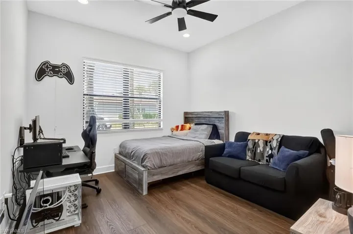 Bedroom with wood finished floors, a desk, recessed lighting, and a ceiling fan