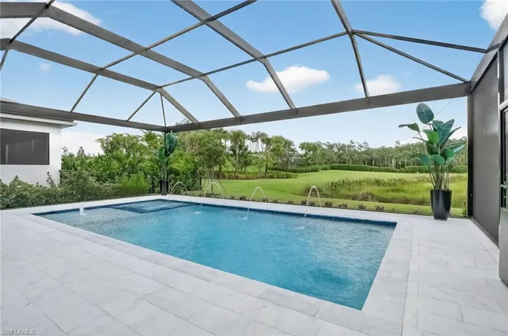 Outdoor pool with a sunroom, a yard, glass enclosure, and a patio area