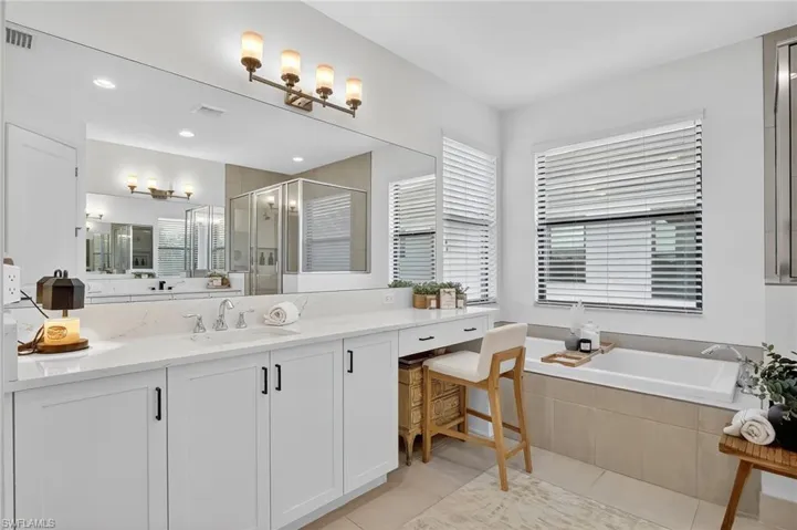 Full bath with a stall shower, vanity, a garden tub, and light tile patterned floors