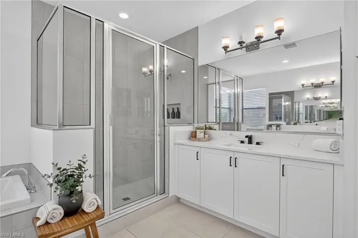 Bathroom with a stall shower, a bath, vanity, light tile patterned floors, and recessed lighting