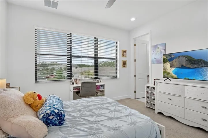 Bedroom with light colored carpet, ceiling fan, and recessed lighting