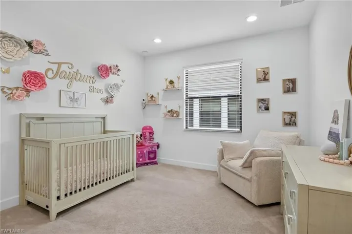 Bedroom featuring light carpet, a nursery area, and recessed lighting