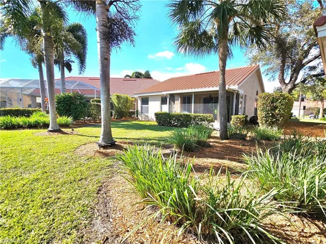 View of front facade with a front yard and glass enclosure