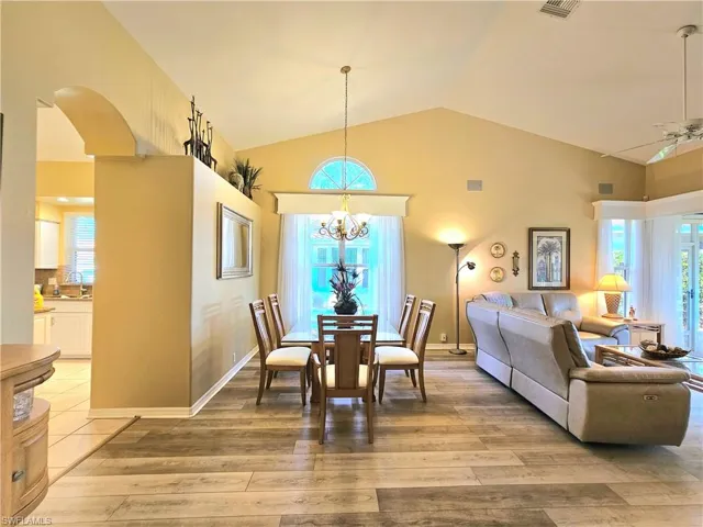 Dining space with light hardwood / wood-style flooring, plenty of natural light, and vaulted ceiling