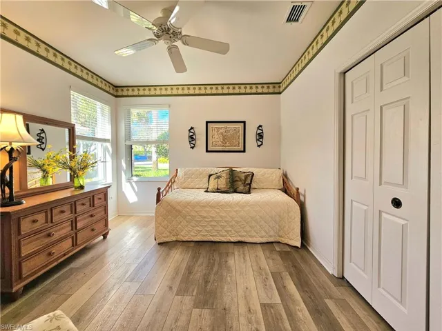 Bedroom with hardwood / wood-style floors, ceiling fan, and a closet