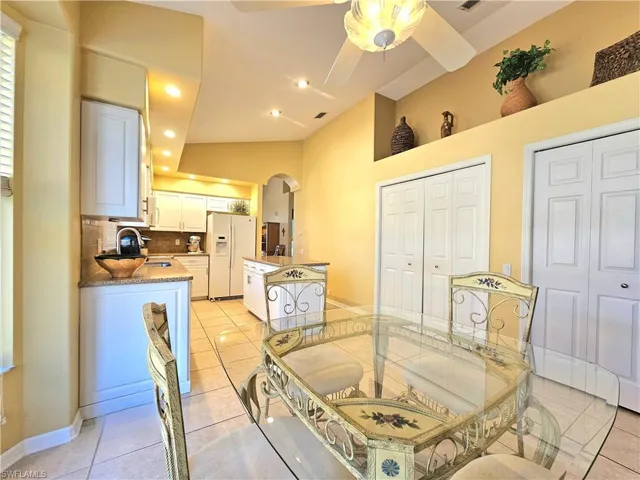 Dining area featuring sink, light tile patterned floors, and ceiling fan