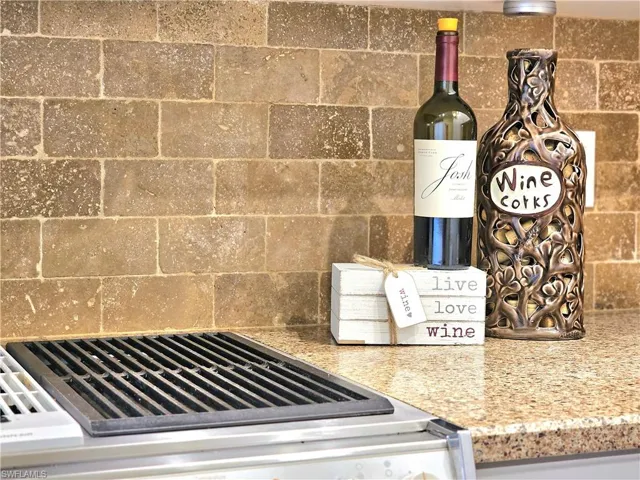 Interior details with light stone counters and decorative backsplash
