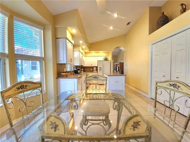 Dining room featuring light tile patterned floors and high vaulted ceiling