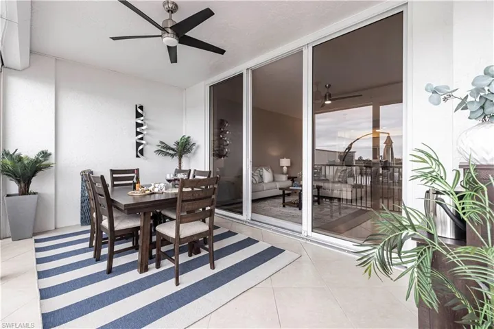 Dining space with ceiling fan, light tile patterned floors, a textured ceiling, and a textured wall