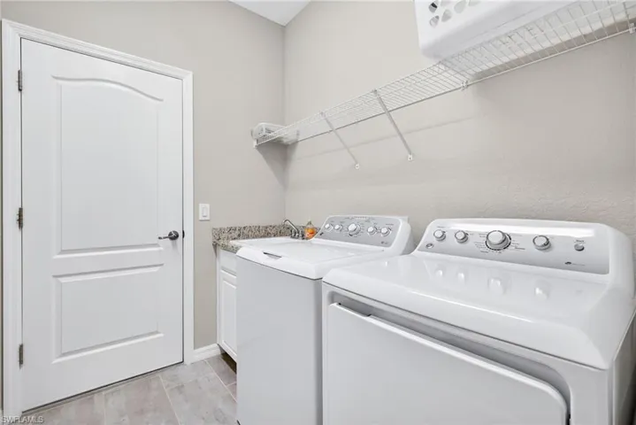 Laundry room with independent washer and dryer and cabinet space