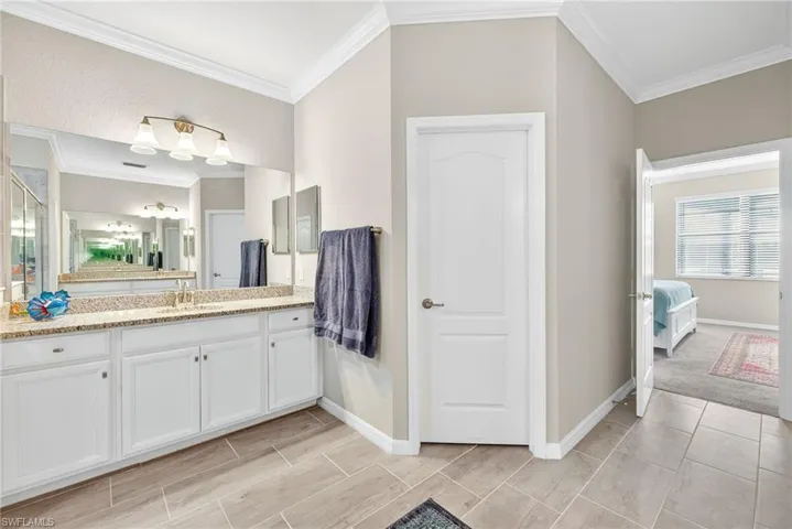 Ensuite bathroom with vanity and ornamental molding