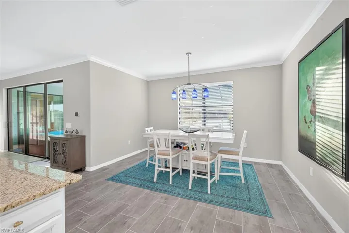 Dining space featuring ornamental molding and wood tiled floors