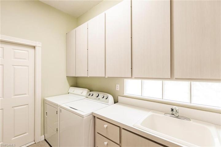 Laundry room with valuable storage space and laundry sink.