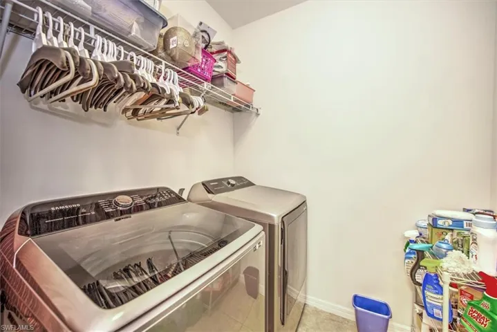 Laundry area featuring tile patterned floors and washer and dryer