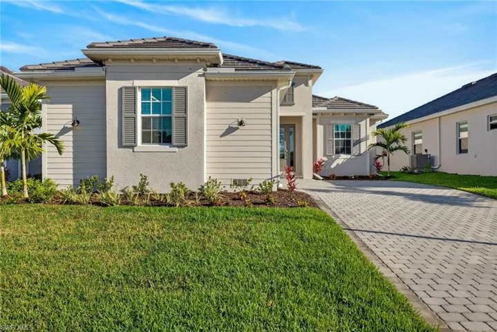 View of front of house with a front yard, stucco siding, and driveway