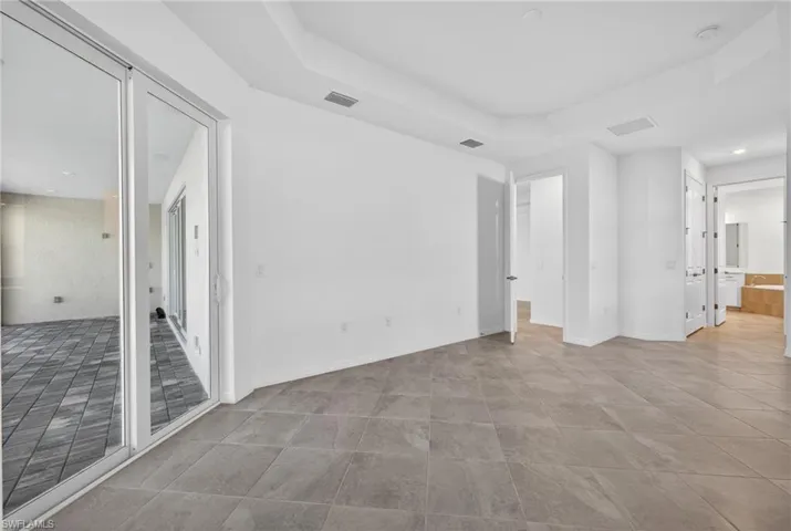 Primary Bedroom featuring recessed lighting and a raised ceiling