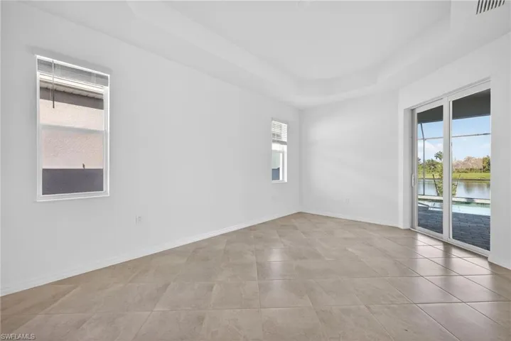 Primary Bedroom with a raised ceiling and a water view