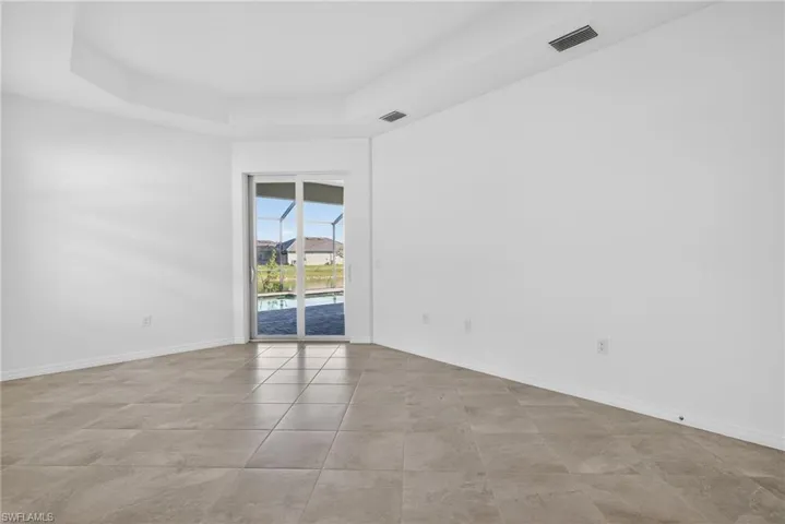 Primary Bedroom featuring a raised ceiling and light tile patterned flooring
