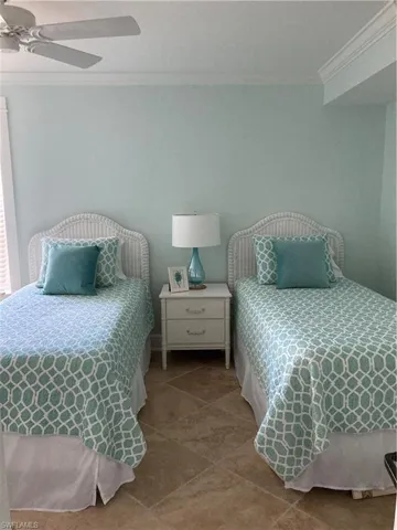 Bedroom featuring crown molding, tile patterned floors, and a ceiling fan