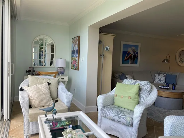 Living room featuring tile patterned floors and crown molding