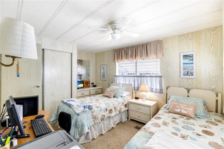 Bedroom with a closet, a ceiling fan, and light carpet