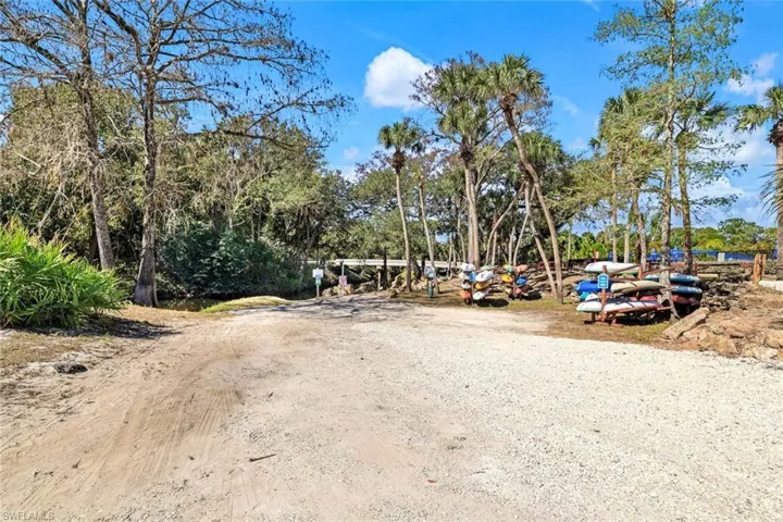 View of dirt / gravel road featuring view of wooded area