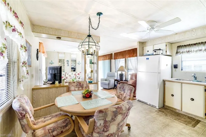 Dining room with ceiling fan, healthy amount of natural light, suspended lighting, and light flooring