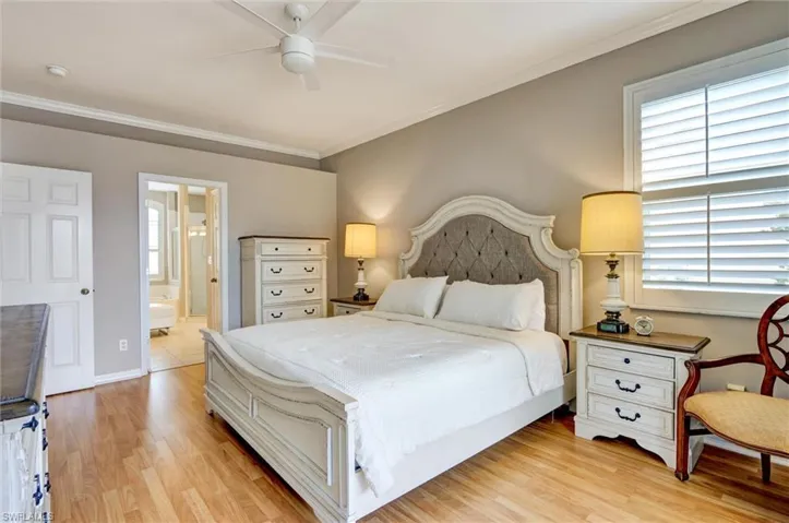 Spacious room featuring wood-finish flooring, a ceiling fan, crown molding, and a window with plantation shutters
