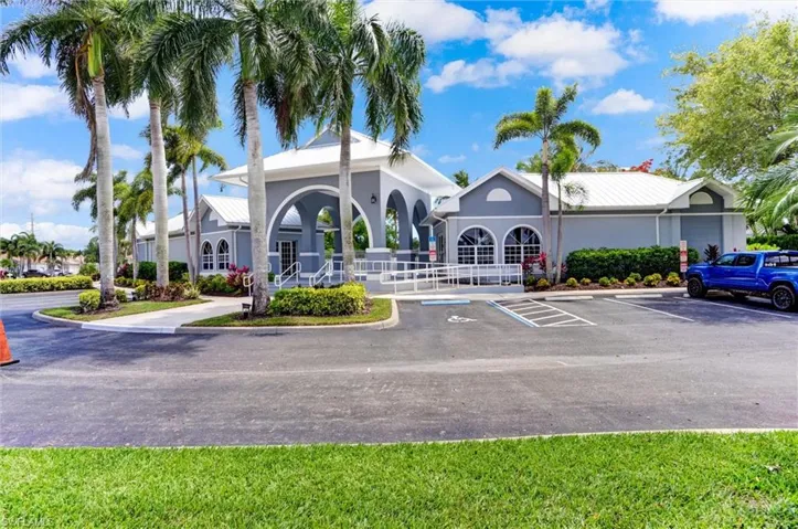 Spacious paved parking area fronting a building with a light gray exterior, white trim, and a white metal roof