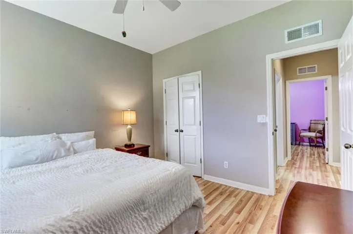 Bedroom featuring neutral wall paint, light wood-finish flooring, and white bi-fold closet doors