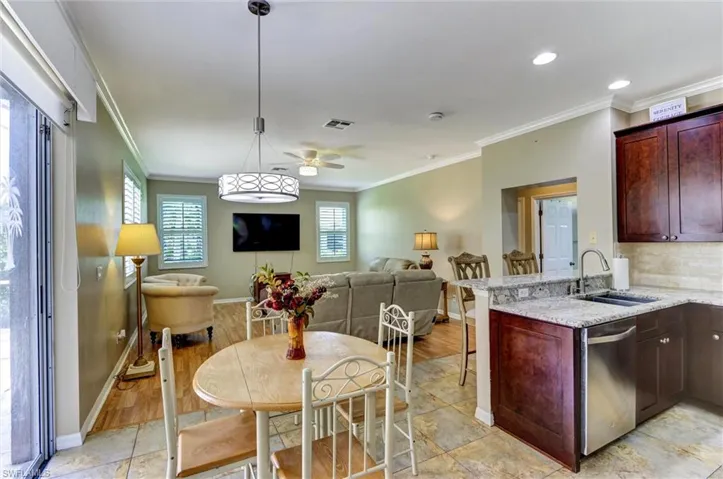 Kitchen area featuring dark wood-finish cabinetry, granite countertops, and a stainless steel appliance