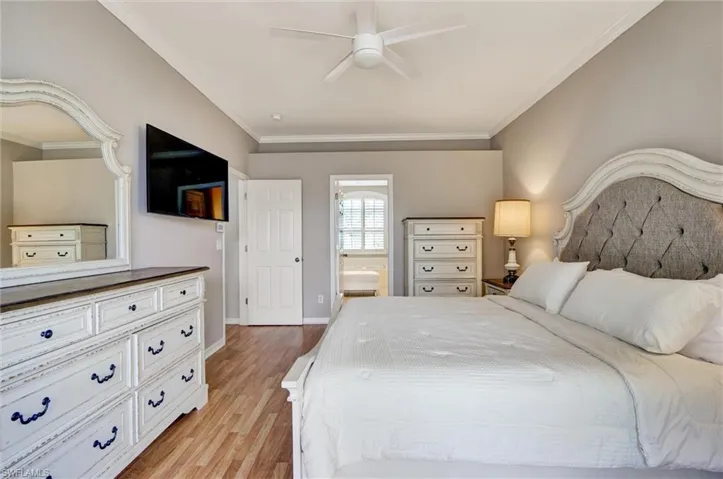 Spacious bedroom featuring wood-finish flooring and a ceiling fan