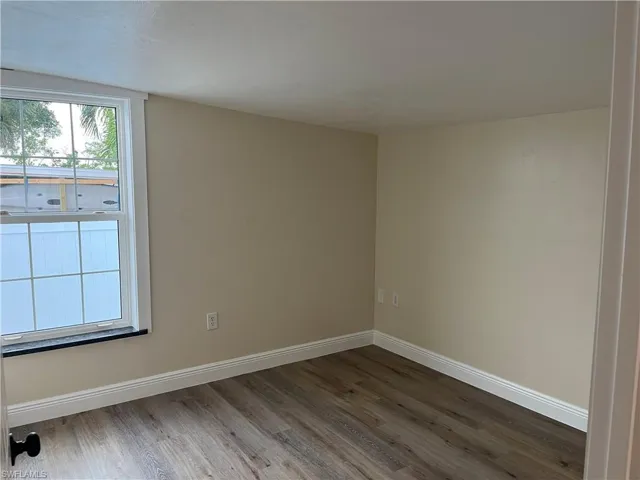 Light-filled interior space featuring wood-finish flooring, neutral wall tones, and white baseboards